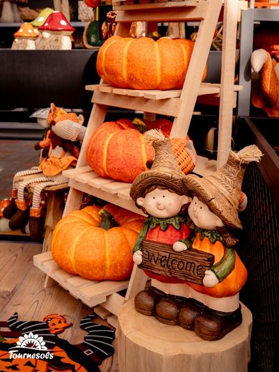 Décorations automnales avec citrouilles et figurines de bienvenue.